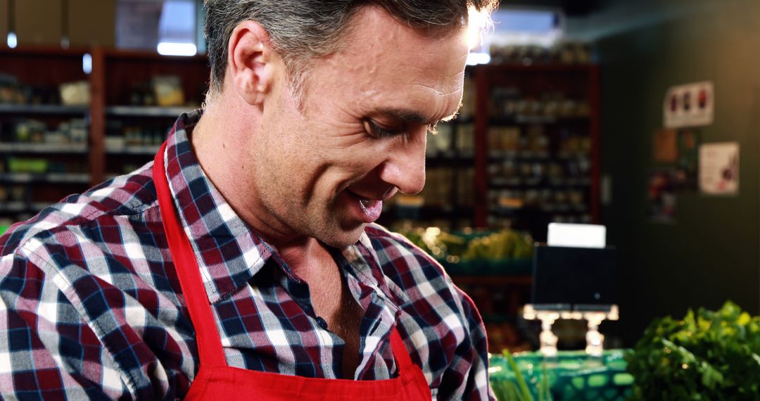 Smiling Grocery Store Clerk Wearing Red Apron - Free Images, Stock Photos and Pictures on Pikwizard.com