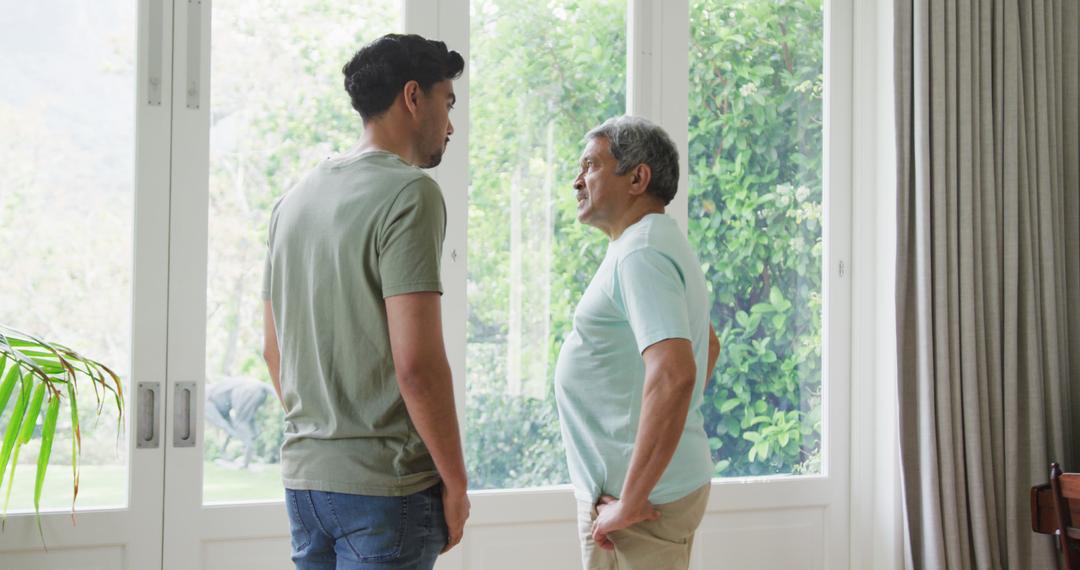 Father and Son having Serious Conversation by Glass Door with Garden View - Free Images, Stock Photos and Pictures on Pikwizard.com