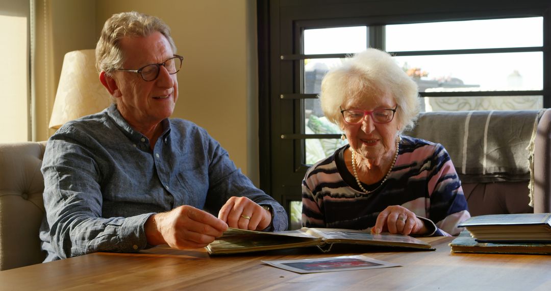 Senior Couple Enjoying Memories with Photo Album - Free Images, Stock Photos and Pictures on Pikwizard.com