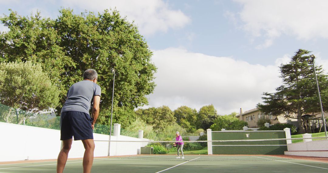 Senior Men Playing Tennis on Outdoor Court in Serene Environment - Free Images, Stock Photos and Pictures on Pikwizard.com