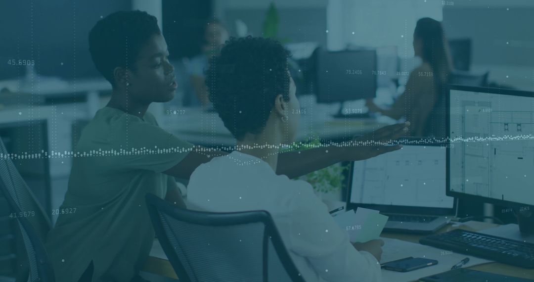 Focused Coworkers Collaborating on Data Analysis on Monitors