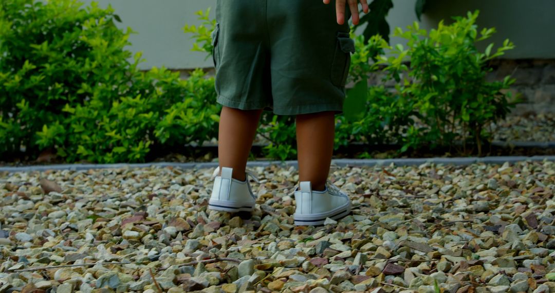 Toddler Exploring Outdoor Garden in Green Shorts and White Shoes - Free Images, Stock Photos and Pictures on Pikwizard.com