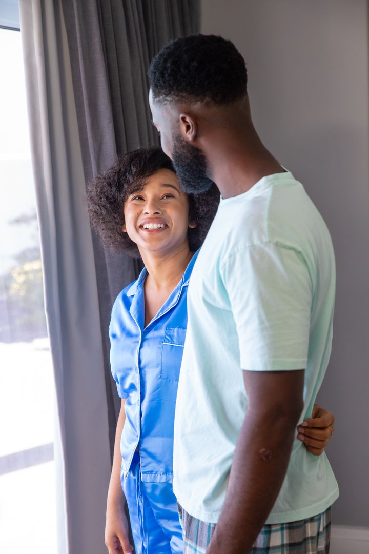 Affectionate Couple in Watchful Embrace by Sunny Window
