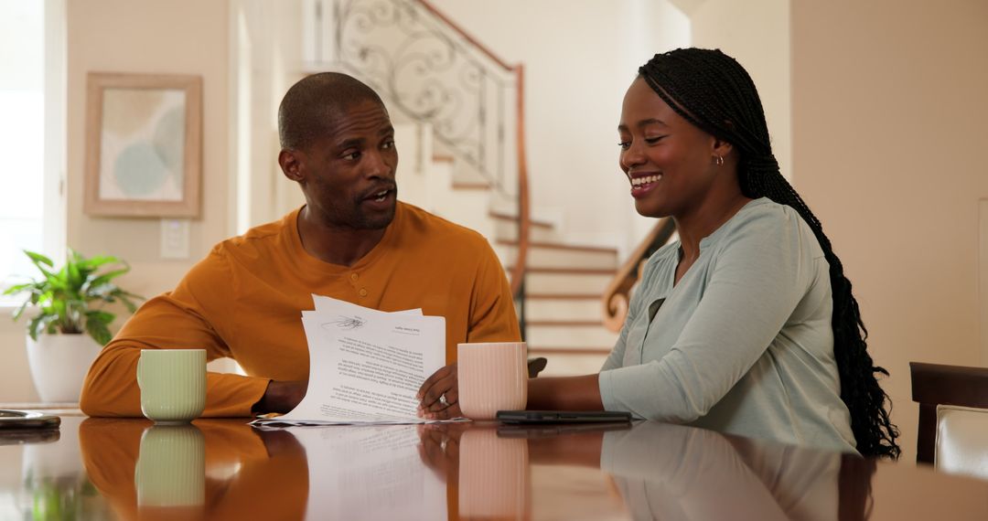 Couple Discussing Finances at Home Brightly Over Documents