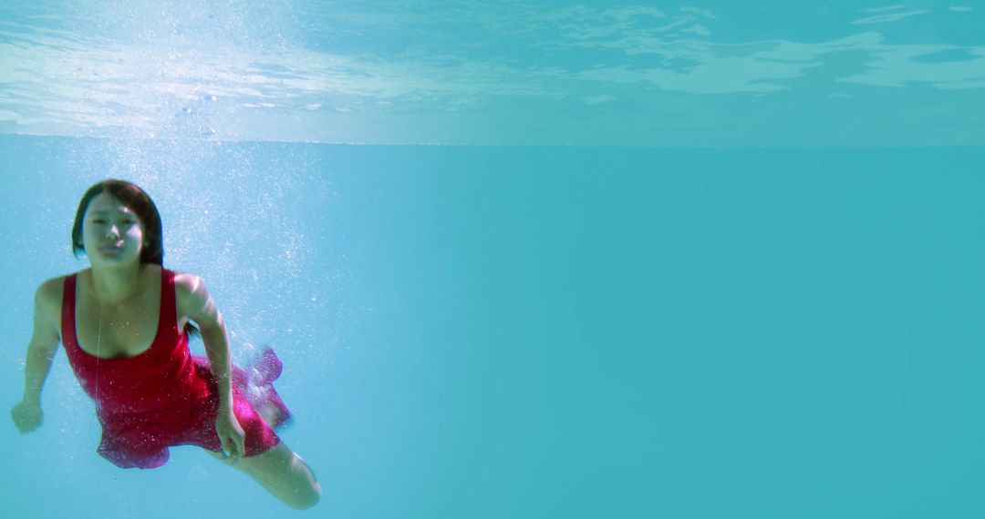 Woman Swimming Underwater in Red Swimsuit - Free Images, Stock Photos and Pictures on Pikwizard.com