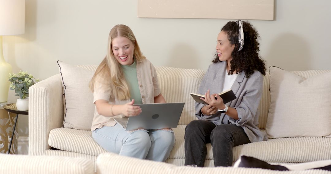 Women Collaborating on Sofa with Laptop and Notebook