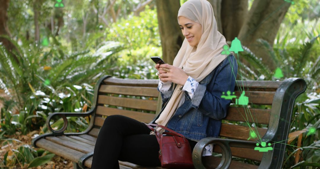 Muslim Woman Connecting with Smartphone in Park - Free Images, Stock Photos and Pictures on Pikwizard.com