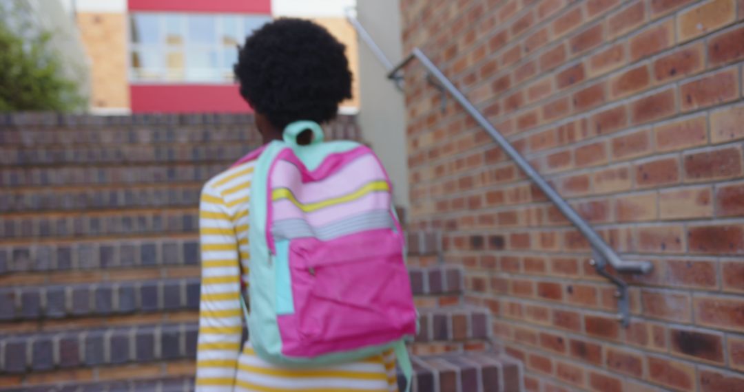 Child with Colorful Backpack Walking Upstairs in Urban Setting