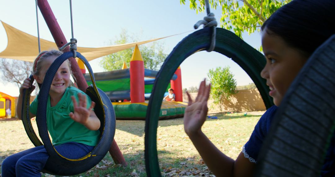 Two Children Playing on Tire Swings in Outdoor Playground - Free Images, Stock Photos and Pictures on Pikwizard.com