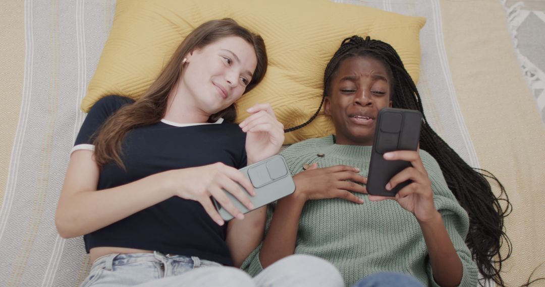 Diverse Teen Girls Relaxing on Bed with Smartphones - Free Images, Stock Photos and Pictures on Pikwizard.com