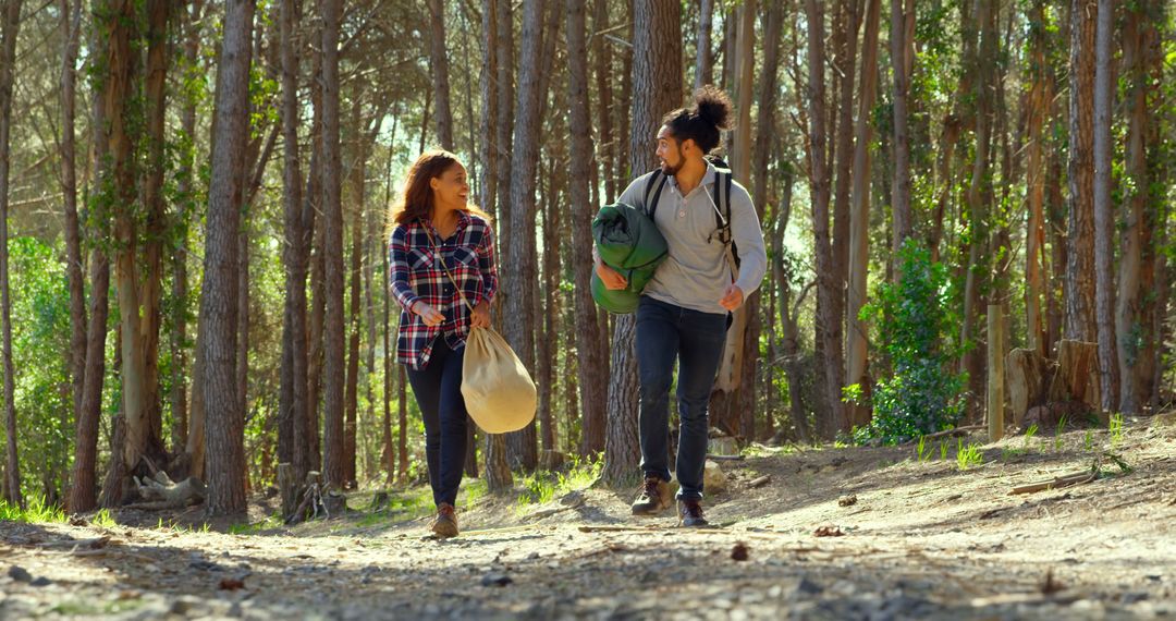 Couple Hiking in Forest Carrying Camping Gear Smiling at Each Other - Free Images, Stock Photos and Pictures on Pikwizard.com