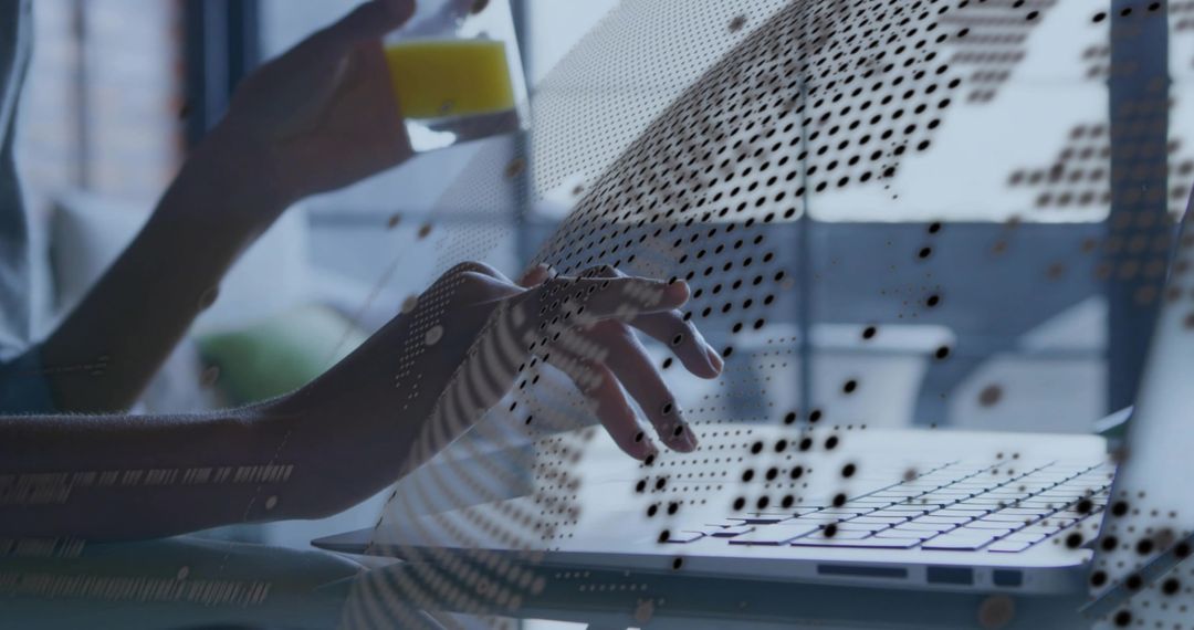 Woman typing on laptop while holding glass with dotted digital data overlay in workspace