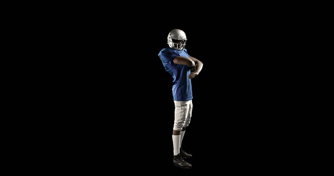 American Football Player Stretching Prepares for Game on Black Background - Free Images, Stock Photos and Pictures on Pikwizard.com