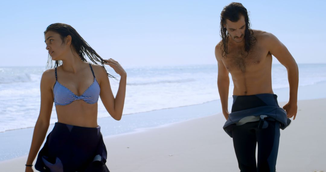 Young Caucasian man and biracial woman enjoy a sunny beach day - Free Images, Stock Photos and Pictures on Pikwizard.com