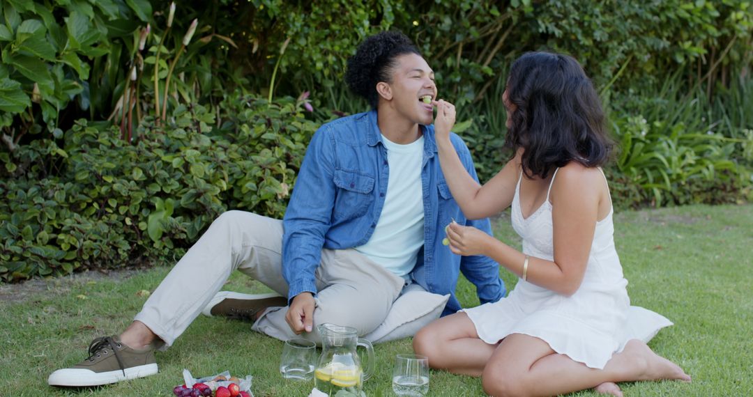 Joyful Couple Enjoying Outdoor Picnic with Fresh Fruits and Drinks