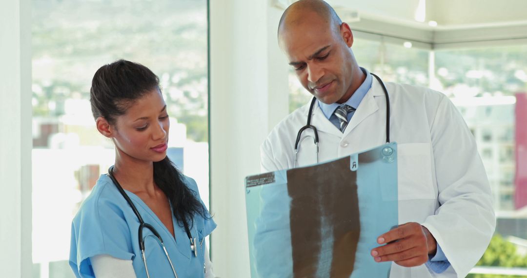 Experienced Doctor Explaining X-ray Results to Nurse in Medical Office - Free Images, Stock Photos and Pictures on Pikwizard.com