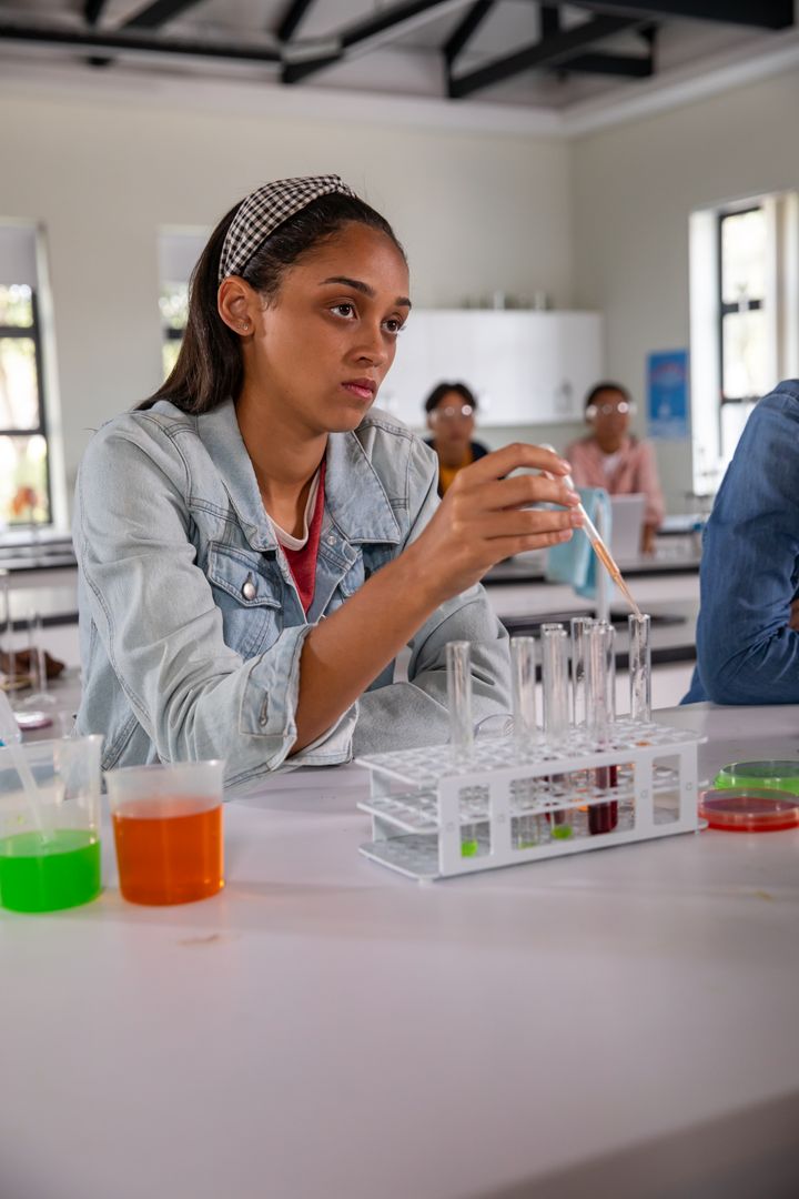 Focused Diverse Teens Conduct Chemistry Experiment Using Pipettes
