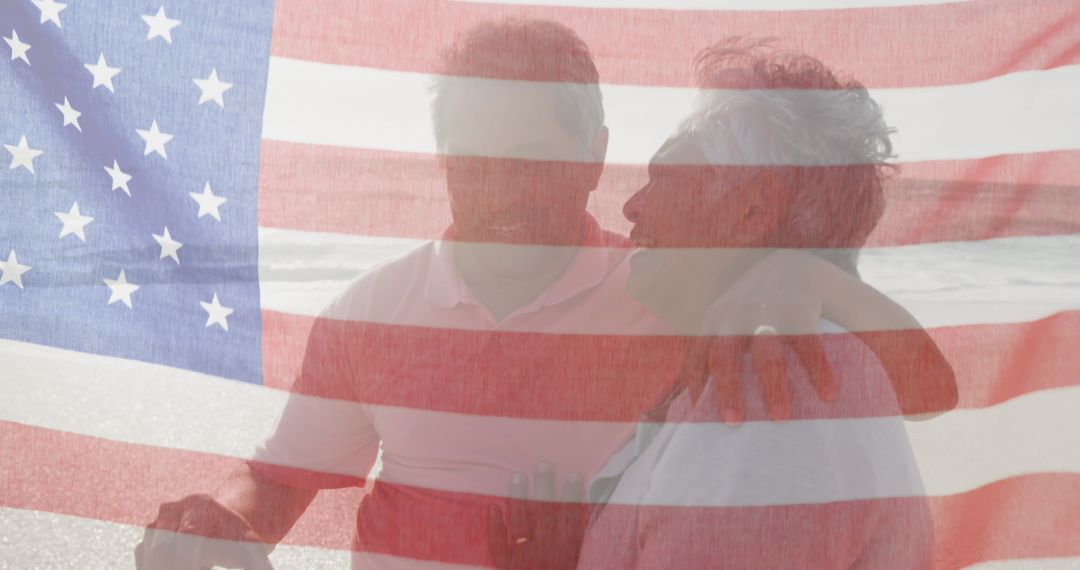 Senior Interracial Couple Embracing Behind American Flag on Beach