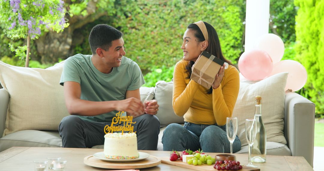Joyful birthday celebration with young couple exchanging gifts