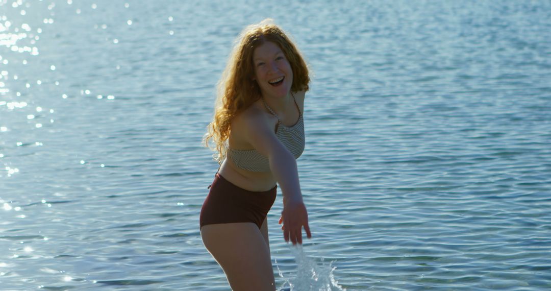 Joyful Woman Playing in Clear Blue Water on Sunny Day - Free Images, Stock Photos and Pictures on Pikwizard.com