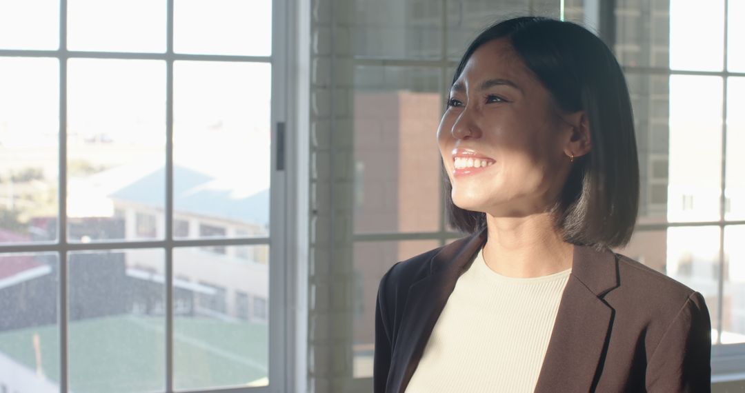 Confident Businesswoman Laughing in Sunlit Office
