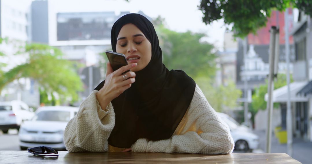 Woman Wearing Hijab Using a Smartphone Outdoors - Free Images, Stock Photos and Pictures on Pikwizard.com