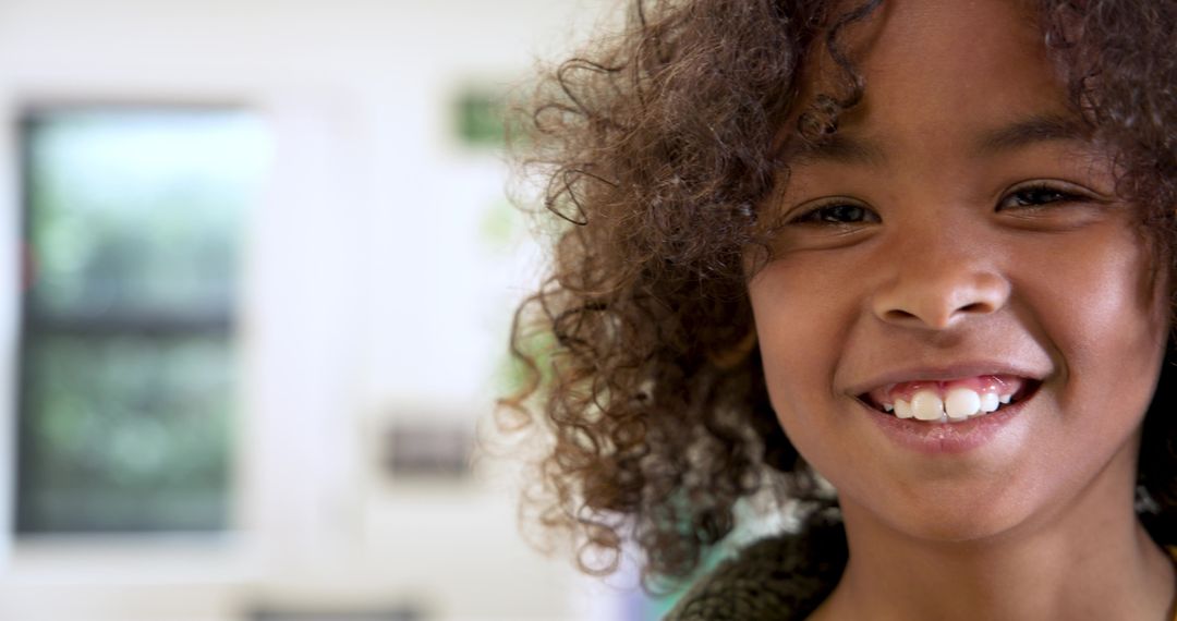 Smiling Boy with Curly Hair Enjoying Sunny Day Indoors