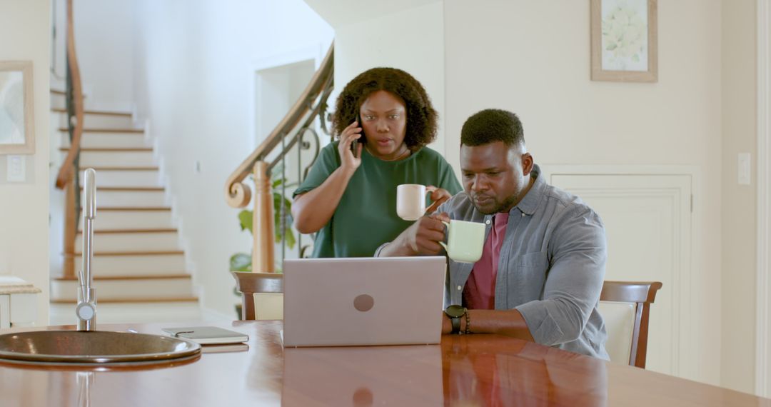 Couple Planning Meeting with Laptop at Home Kitchen Table