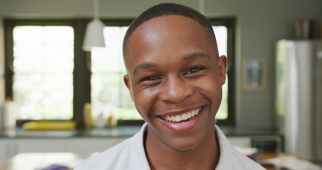 Smiling Young Man In Kitchen With Sunlight - Free Images, Stock Photos and Pictures on Pikwizard.com