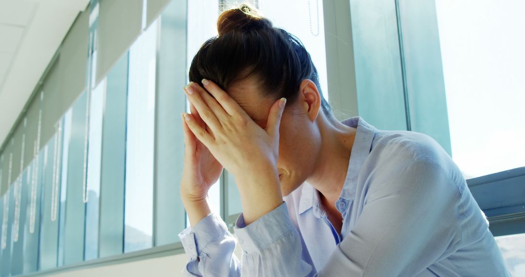 Stressed Woman Holding Head at Work Desk - Free Images, Stock Photos and Pictures on Pikwizard.com