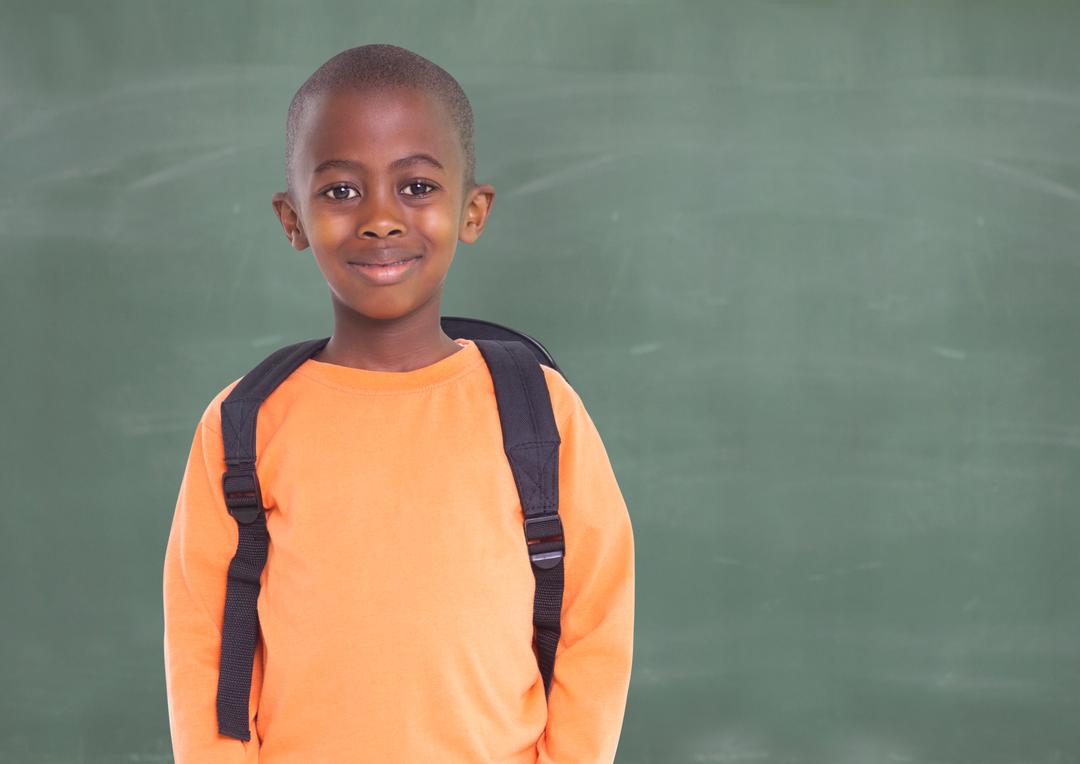 Smiling African American Boy with Backpack Against Green Chalkboard - Free Images, Stock Photos and Pictures on Pikwizard.com