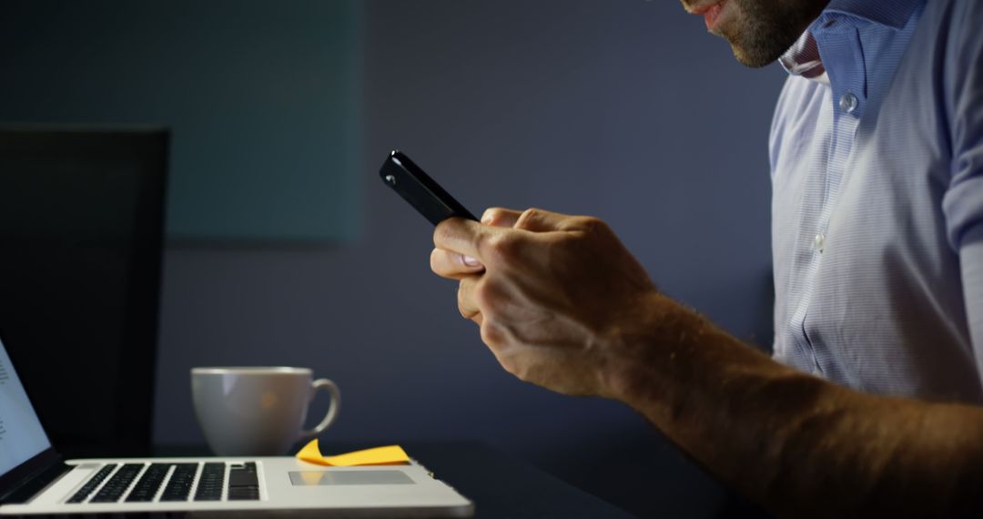 Business Professional Multitasking with Phone and Laptop in Office