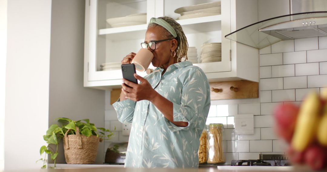 Senior Woman Enjoying Coffee While Checking Smartphone