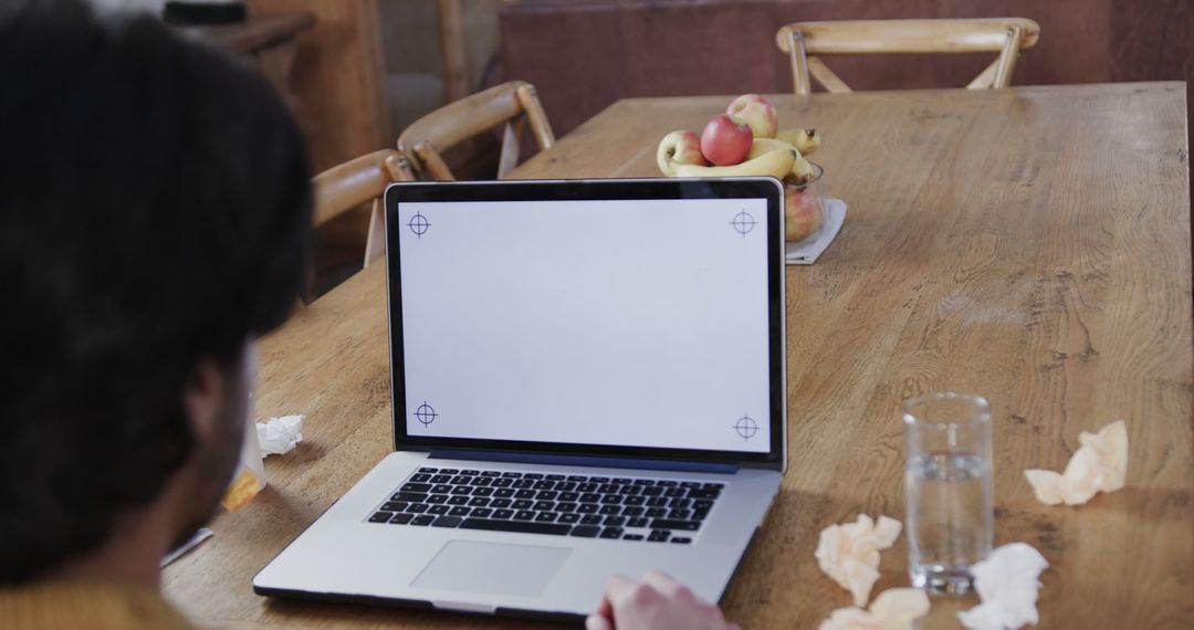 Person Working on Laptop at Wooden Dining Table with Fruit Bowl - Free Images, Stock Photos and Pictures on Pikwizard.com