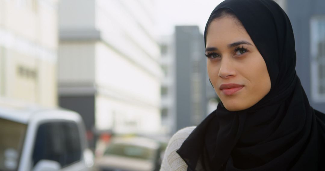 Confident Young Woman in Hijab Reflecting in Urban Environment - Free Images, Stock Photos and Pictures on Pikwizard.com