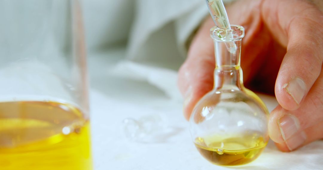 Scientist examining liquid in laboratory glassware - Free Images, Stock Photos and Pictures on Pikwizard.com