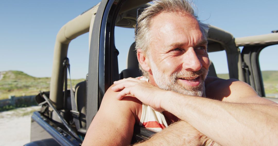 Smiling Man Enjoying Adventure Next to Off-Road Vehicle on Sunny Day - Free Images, Stock Photos and Pictures on Pikwizard.com