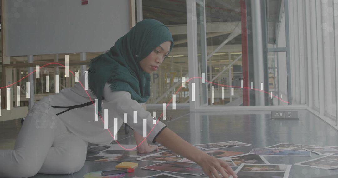 Designer in Studio with Hijab Arranging Photos Amongst Data