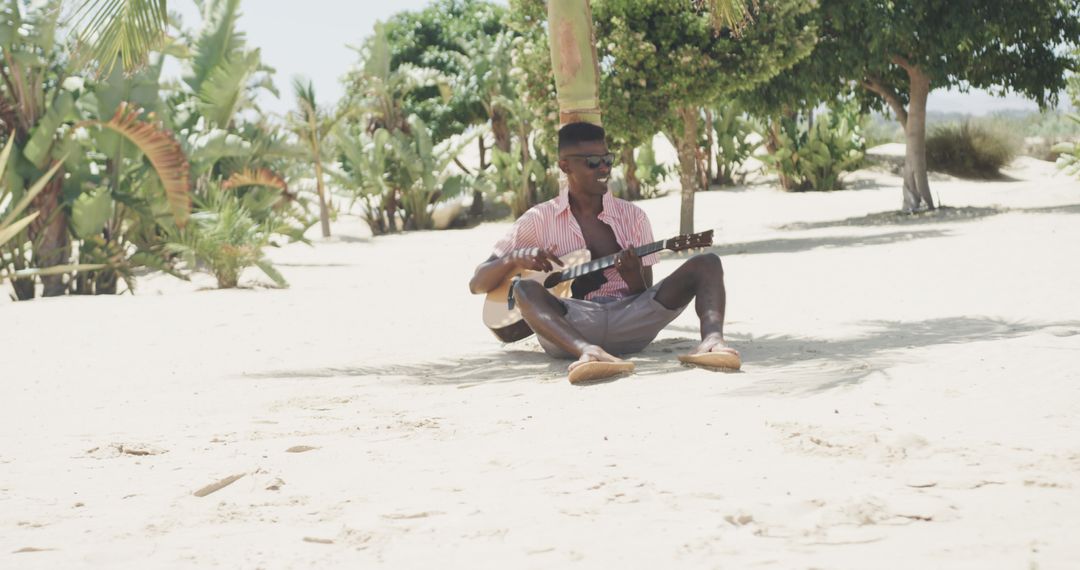 Man Playing Guitar on Tropical Beach under Palm Trees - Free Images, Stock Photos and Pictures on Pikwizard.com