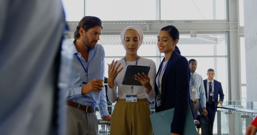 Diverse Professionals Collaborating in Office Lobby with Digital Tablet