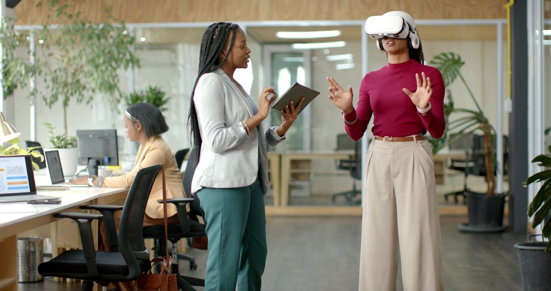 Diverse Female Team Testing VR Headset and Using Tablet for Workplace Training