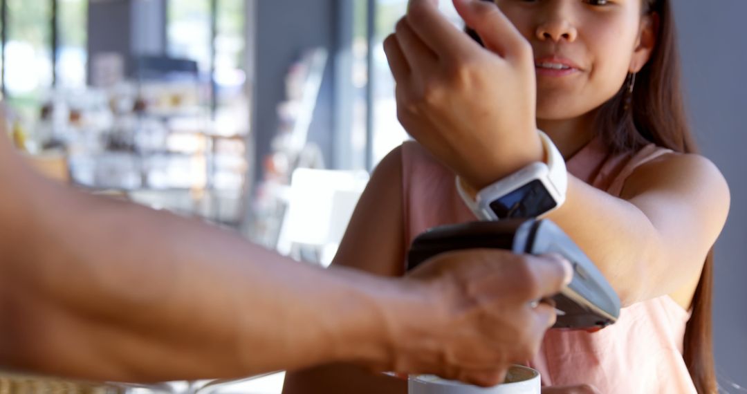 Young Woman Using Smartwatch for Contactless Payment in Coffee Shop - Free Images, Stock Photos and Pictures on Pikwizard.com