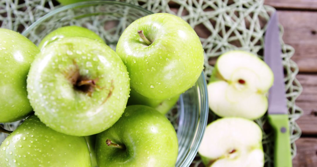 Fresh Green Apples in Glass Bowl with Sliced Apples