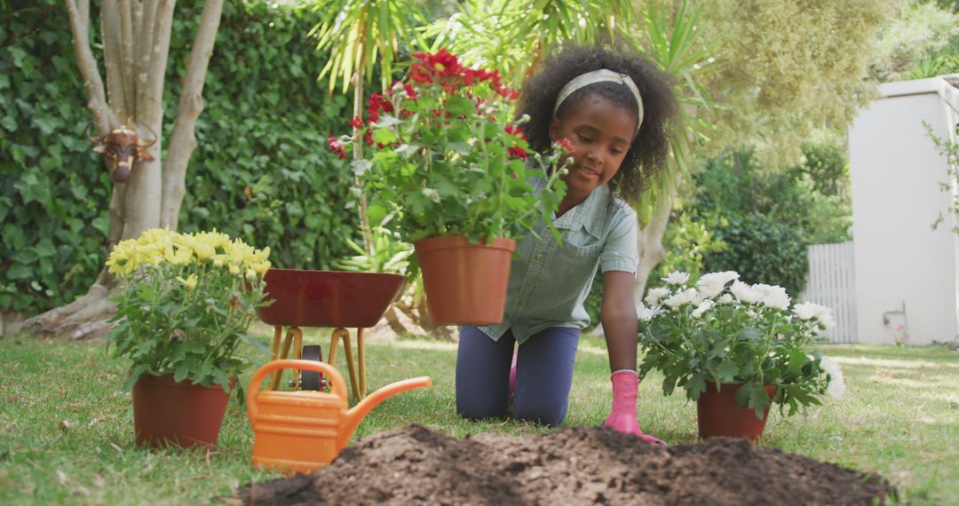 Happy african american girl planting flowers in garden - Free Images, Stock Photos and Pictures on Pikwizard.com