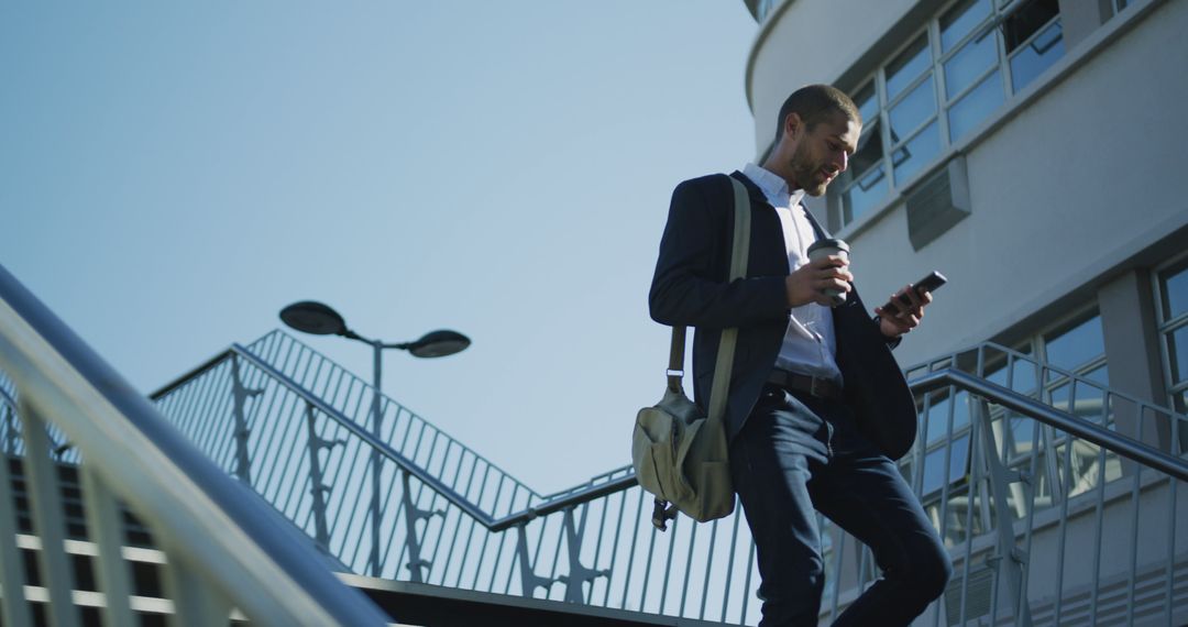 Businessman Walking Down Stairs Using Smartphone - Free Images, Stock Photos and Pictures on Pikwizard.com