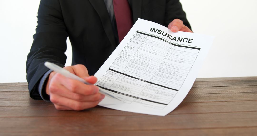 A Caucasian businessman is presenting an insurance form, with copy space - Free Images, Stock Photos and Pictures on Pikwizard.com