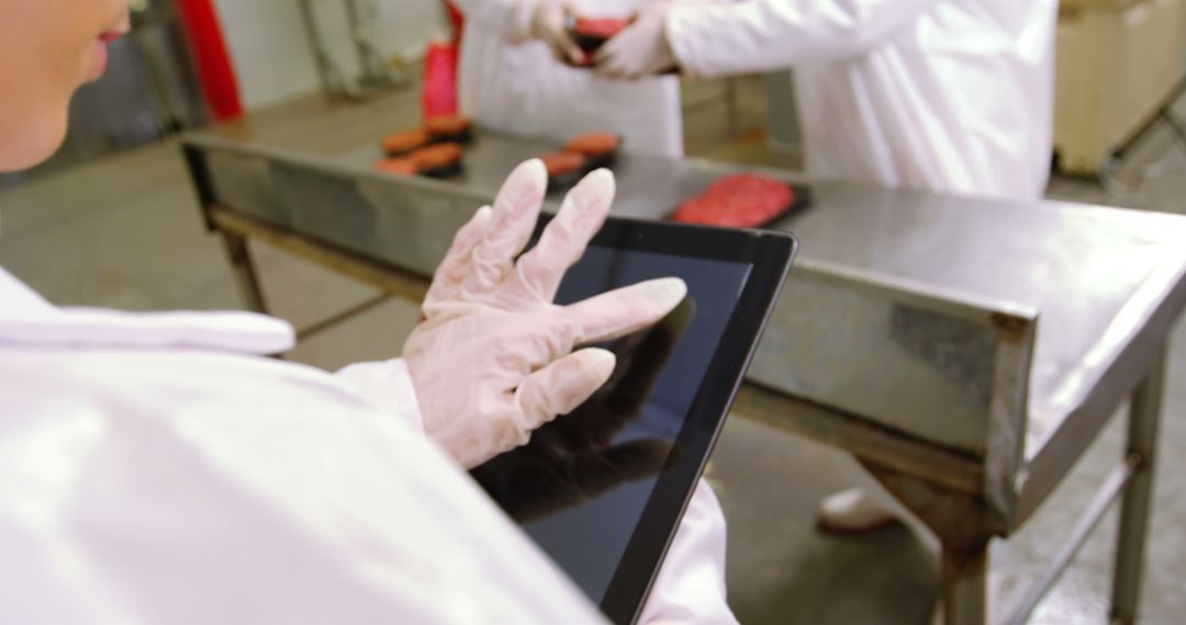 Butcher Using Digital Tablet in Meat Processing Facility - Free Images, Stock Photos and Pictures on Pikwizard.com