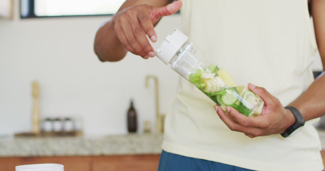 Man Preparing Nutritious Green Smoothie in Kitchen