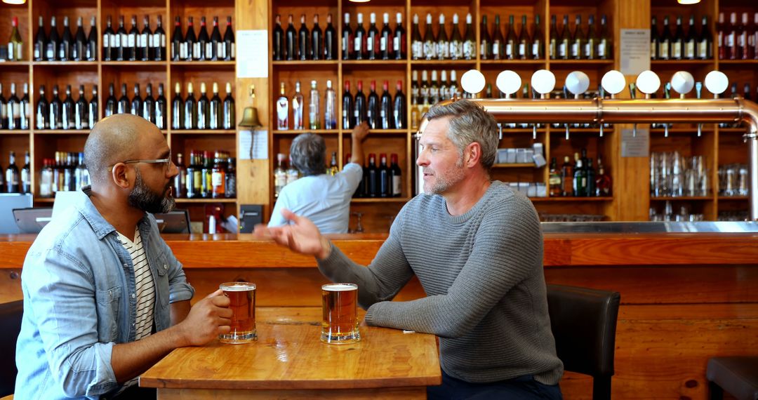 Two Friends Chatting Over Beer in Cozy Pub - Free Images, Stock Photos and Pictures on Pikwizard.com