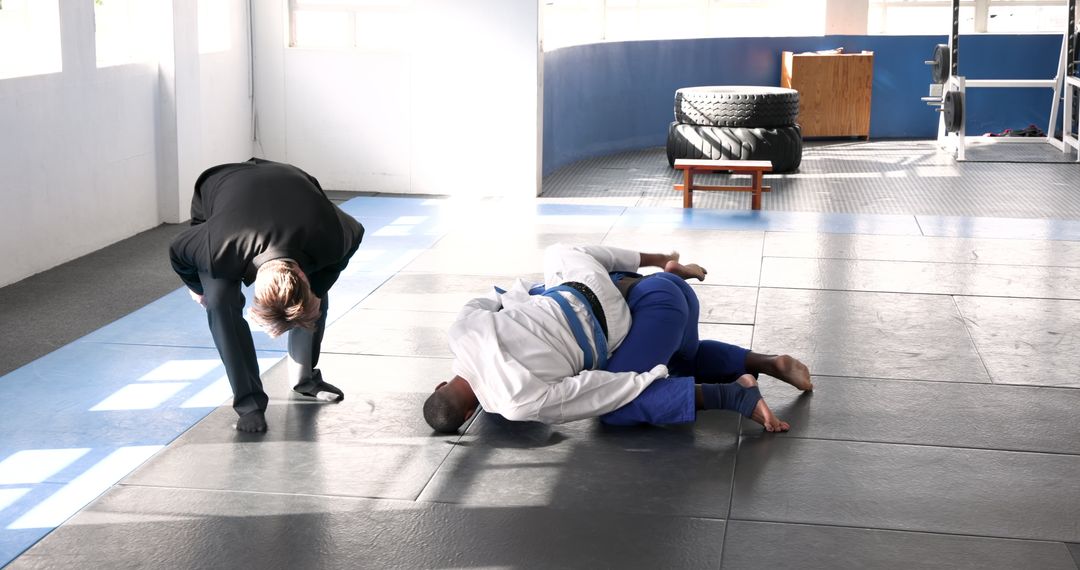 Athletes Practicing Martial Arts Grappling Techniques with Coach's Guidance